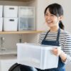 日本の住宅の狭い洗面所を整理整頓し、収納ボックスを笑顔で活用する日本人の女性。清潔感のある空間。